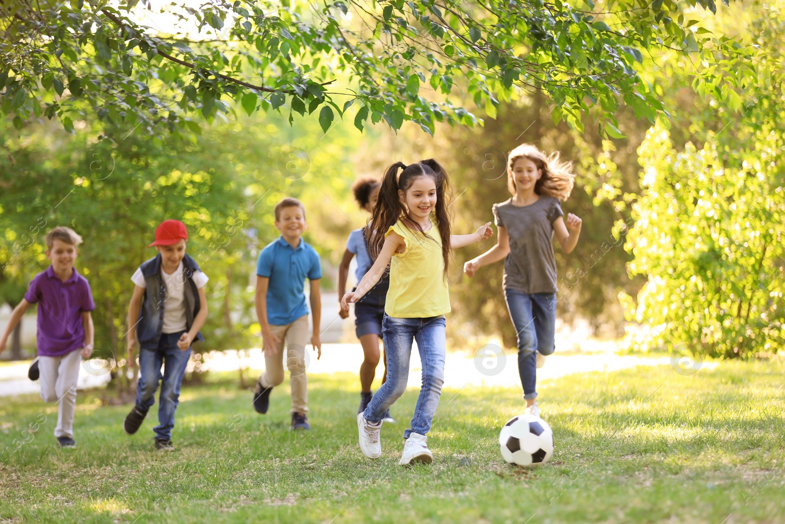 Photo of Cute little children playing with ball outdoors on sunny day