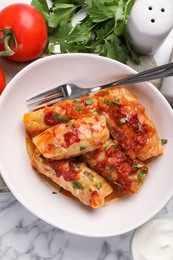 Photo of Delicious stuffed cabbage rolls cooked with homemade tomato sauce on white marble table, flat lay