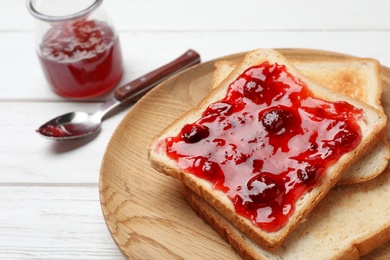 Photo of Toasts with jam on wooden plate, closeup