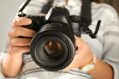 Female photographer with professional camera, closeup view