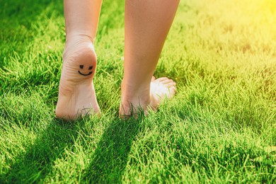 Photo of Teenage girl with smiling face drawn on heel walking outdoors, closeup