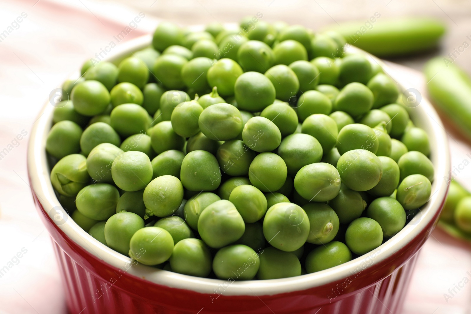 Photo of Bowl with green peas on table, closeup