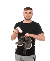Photo of Young man putting powder freshener into shoes on white background