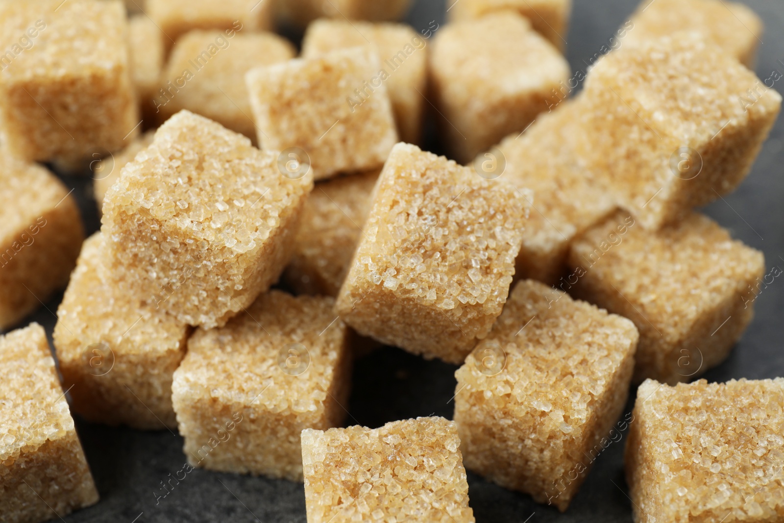 Photo of Brown sugar cubes on table, closeup view