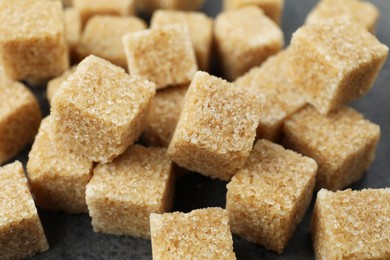 Photo of Brown sugar cubes on table, closeup view