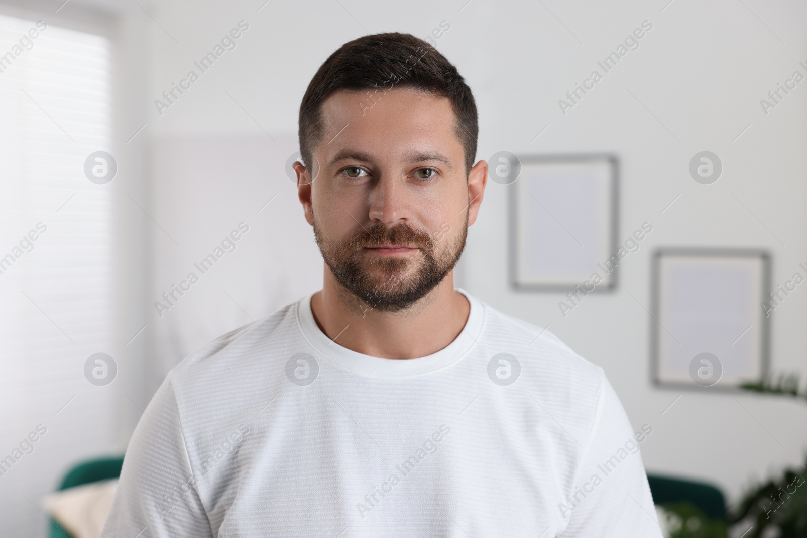 Photo of Portrait of handsome man looking at camera indoors