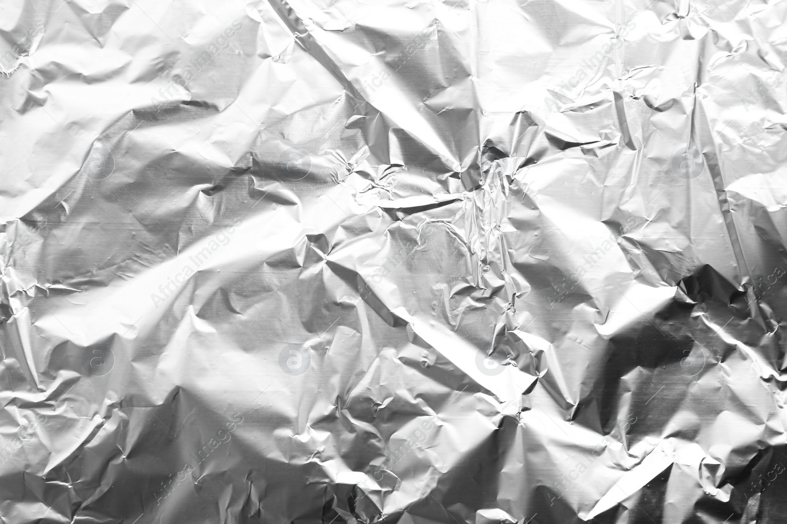 Photo of Crumpled silver foil as background, closeup view