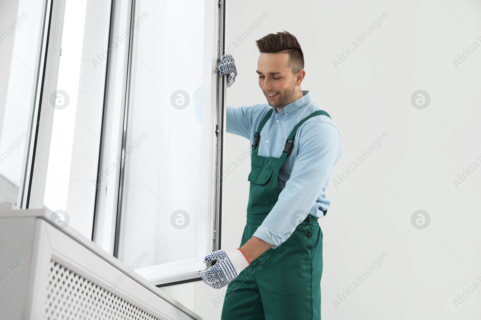 Photo of Construction worker installing plastic window in house