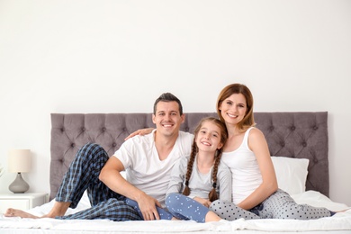 Photo of Happy family with cute child in bedroom