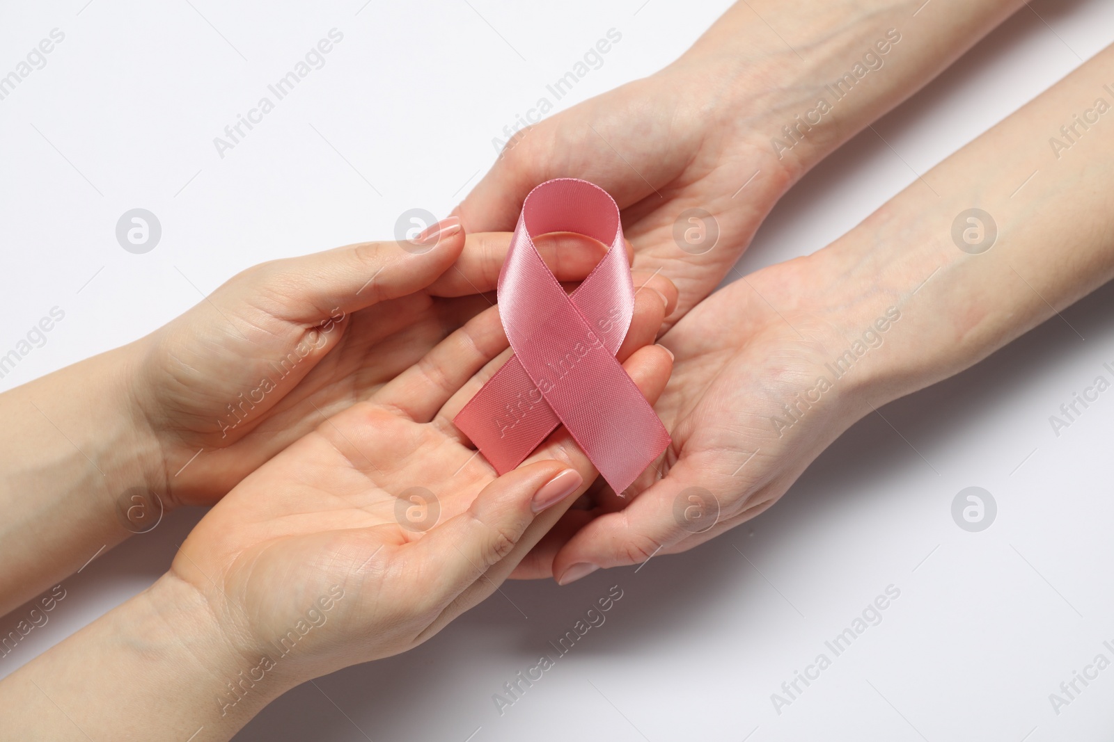 Photo of Women holding pink ribbon on white background, top view. Breast cancer awareness