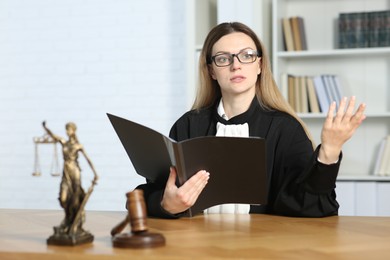 Photo of Judge with folder working indoors, selective focus