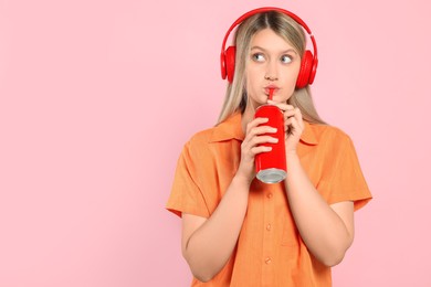 Photo of Beautiful woman drinking from red beverage can on pink background. Space for text