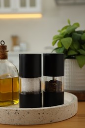 Photo of Salt and pepper shakers and bottle of oil on wooden table