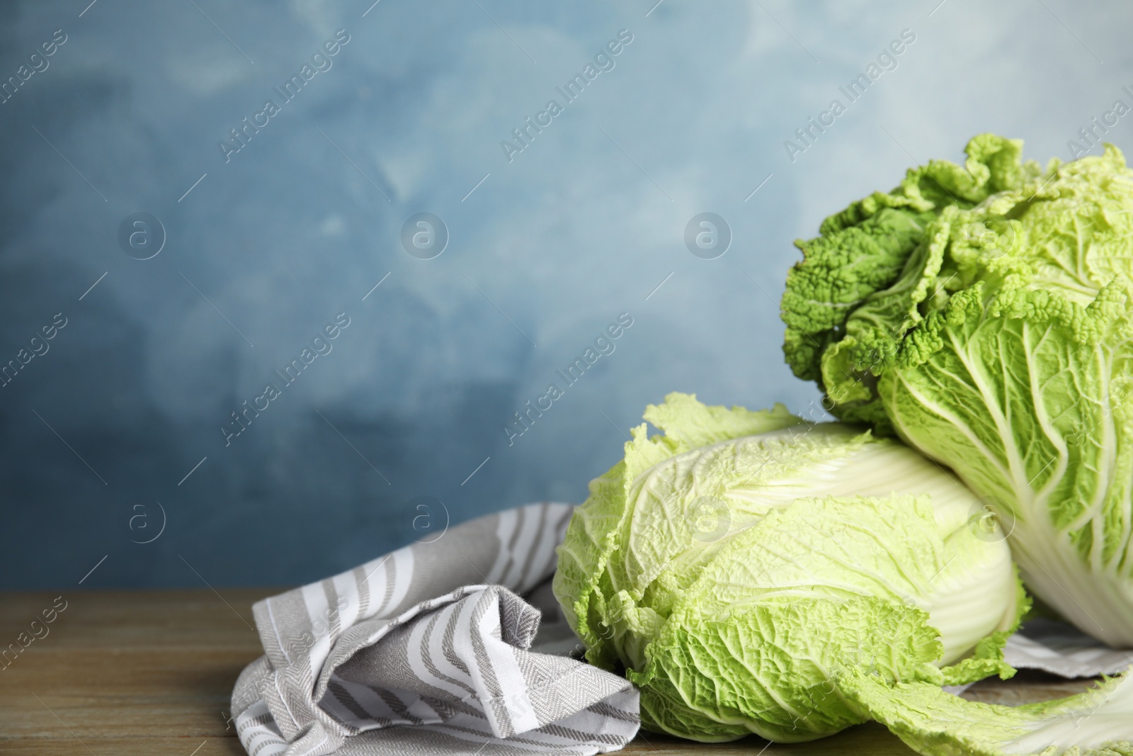 Photo of Fresh ripe Chinese cabbages on wooden table. Space for text