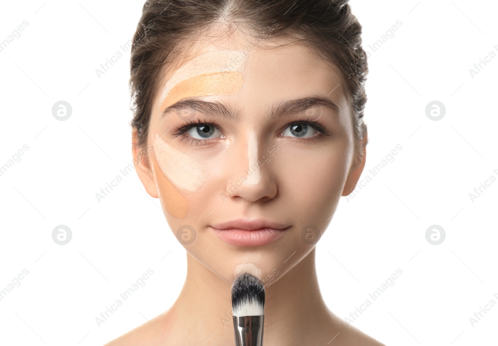 Photo of Beautiful girl applying foundation with brush on white background