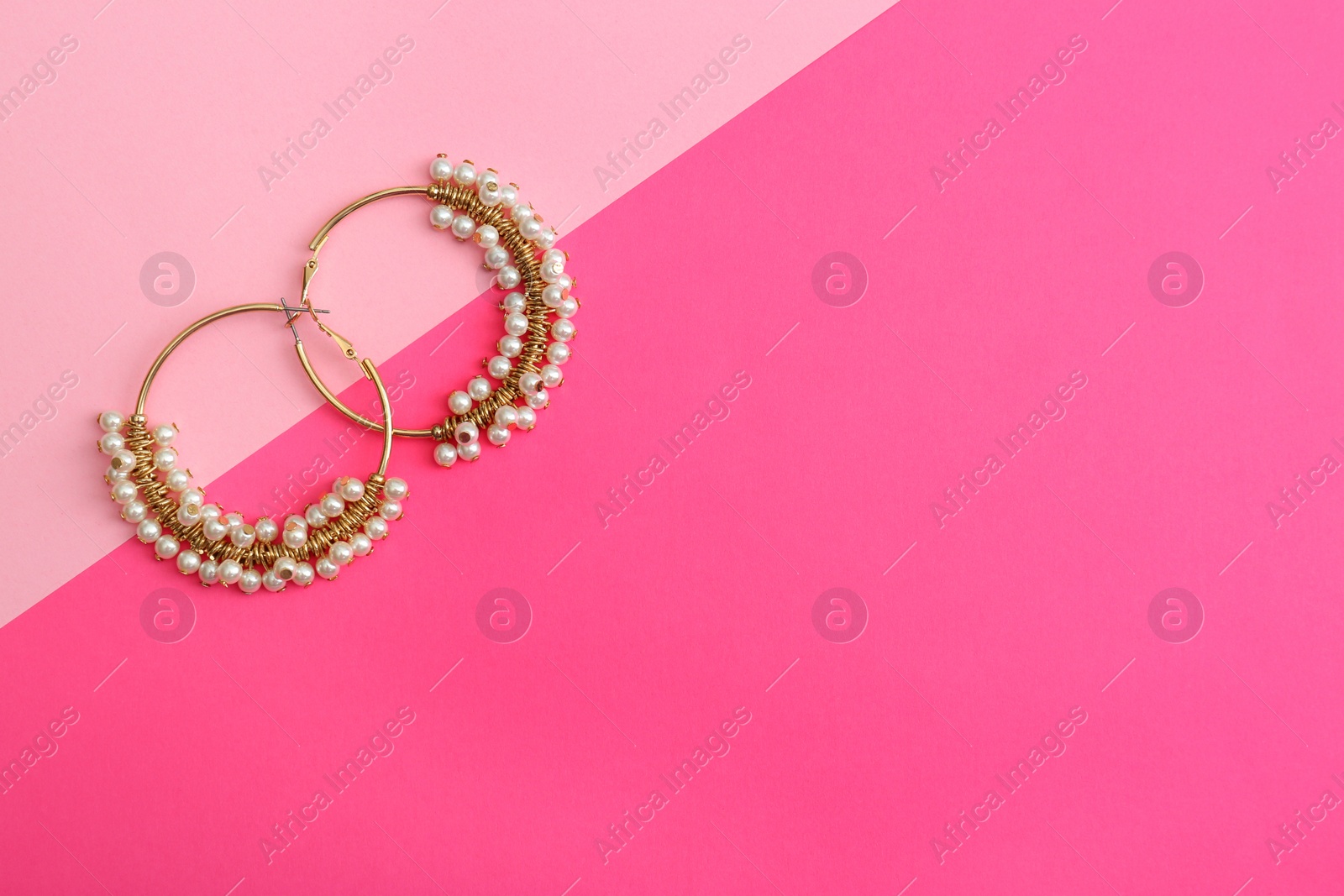 Photo of Beautiful earrings on color background, flat lay. Space for text