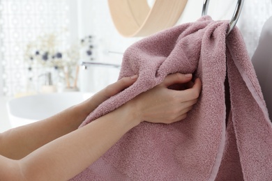 Photo of Woman wiping hands with towel in bathroom, closeup