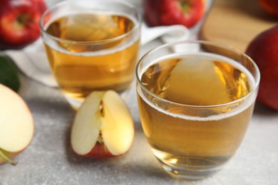 Photo of Delicious cider and ripe apples on grey table