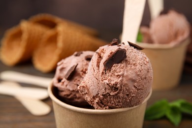 Paper cups with tasty chocolate ice cream on table, closeup