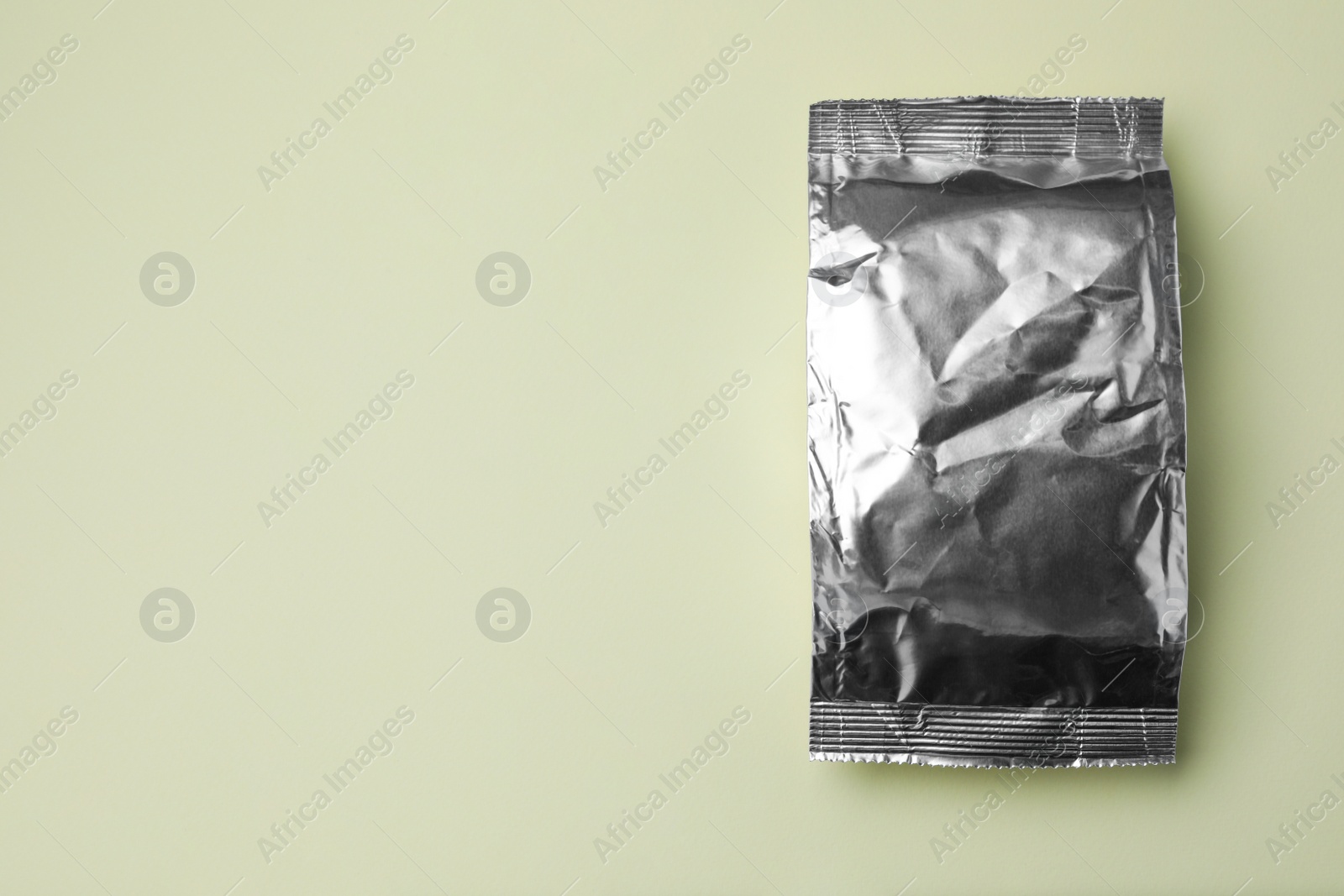 Photo of Blank foil package on light background, top view. Space for text