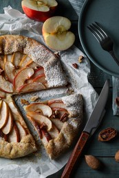 Photo of Delicious apple galette with pecans and knife on wooden table, flat lay