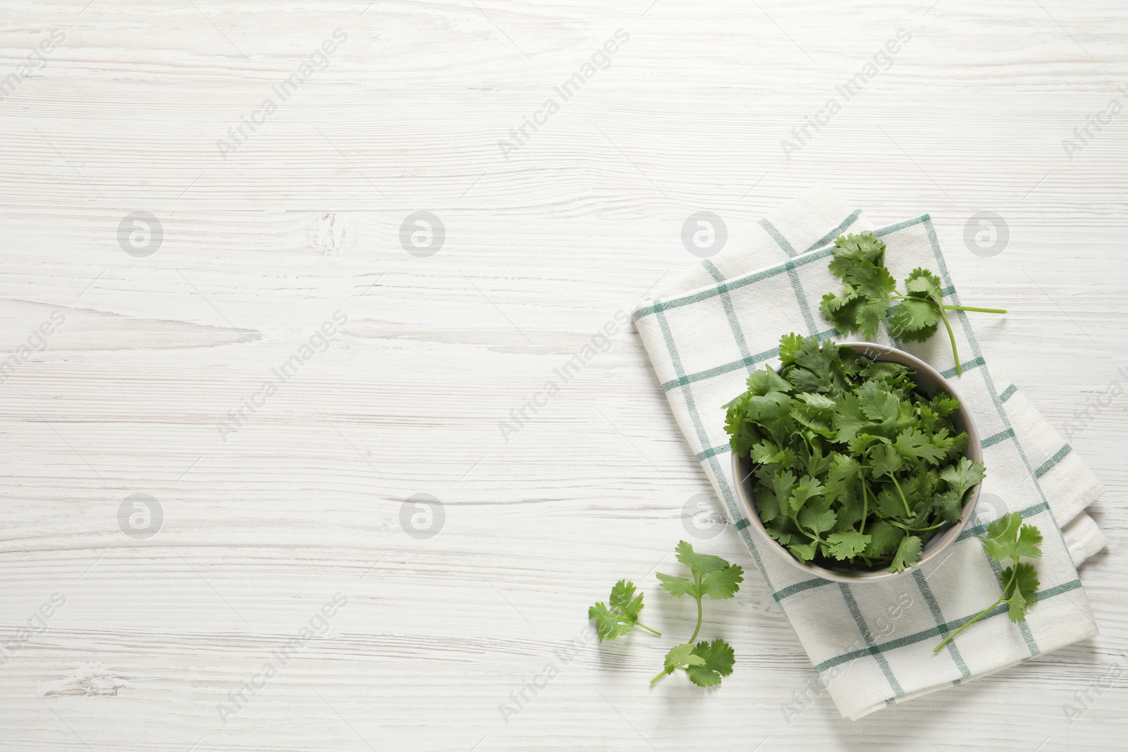 Photo of Fresh aromatic cilantro on white wooden table, flat lay. Space for text