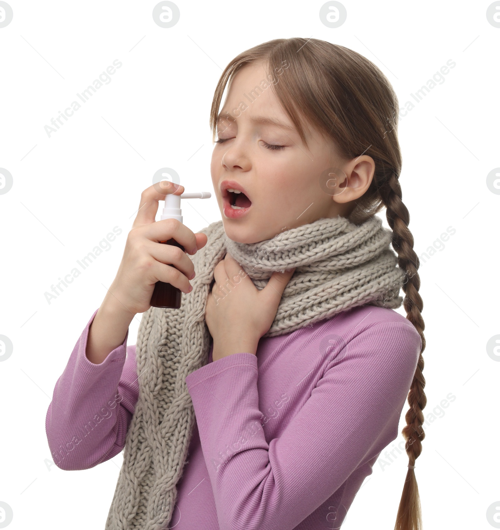 Photo of Little girl with scarf using throat spray on white background