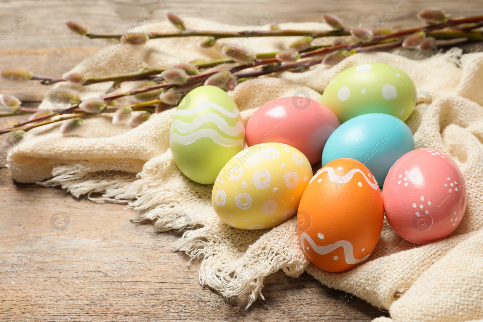 Photo of Colorful painted Easter eggs and cloth on table, space for text