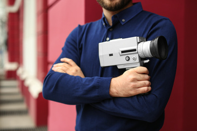 Man with vintage video camera outdoors, closeup