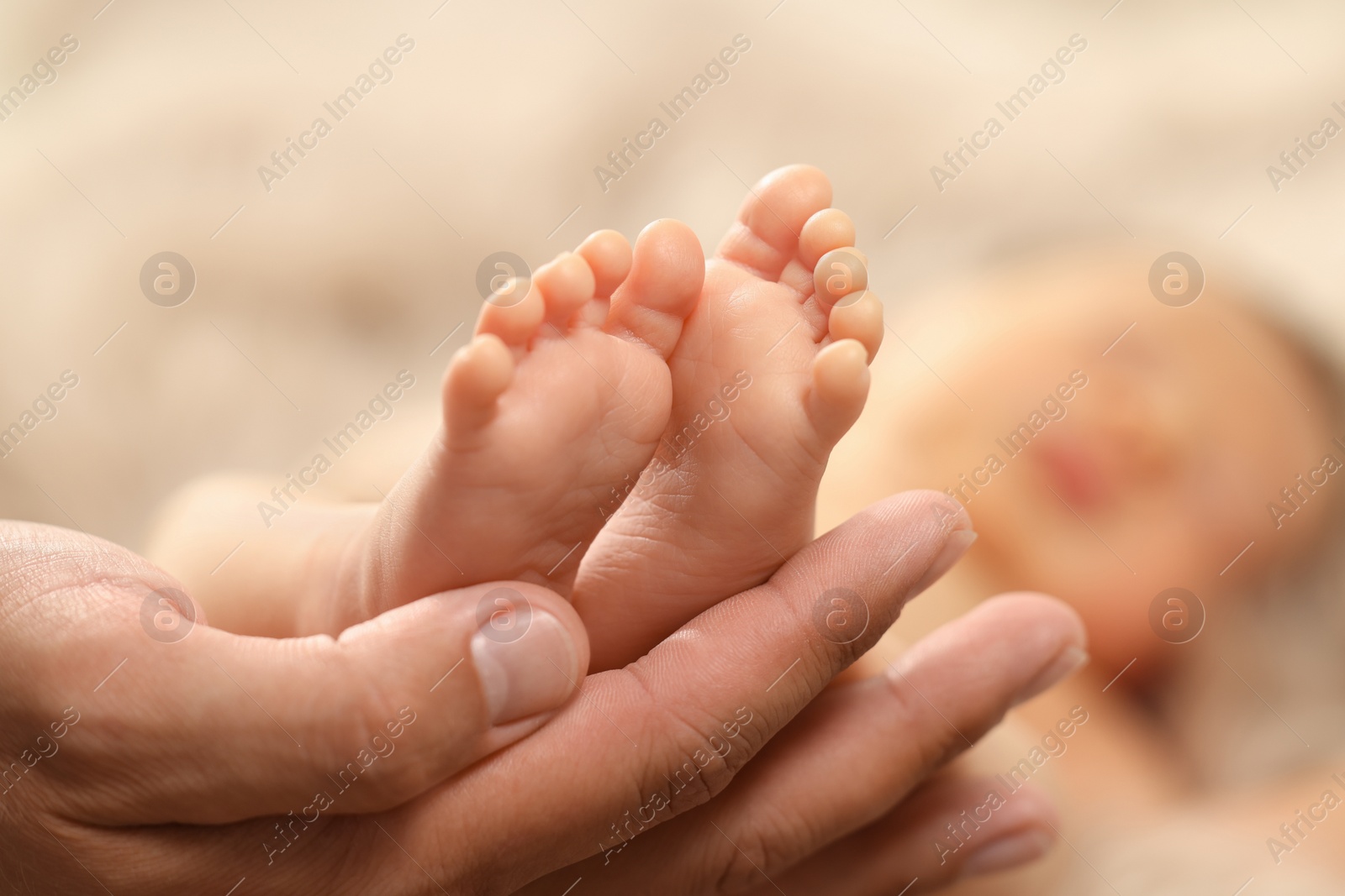 Photo of Father holding his newborn baby, closeup view on feet. Lovely family