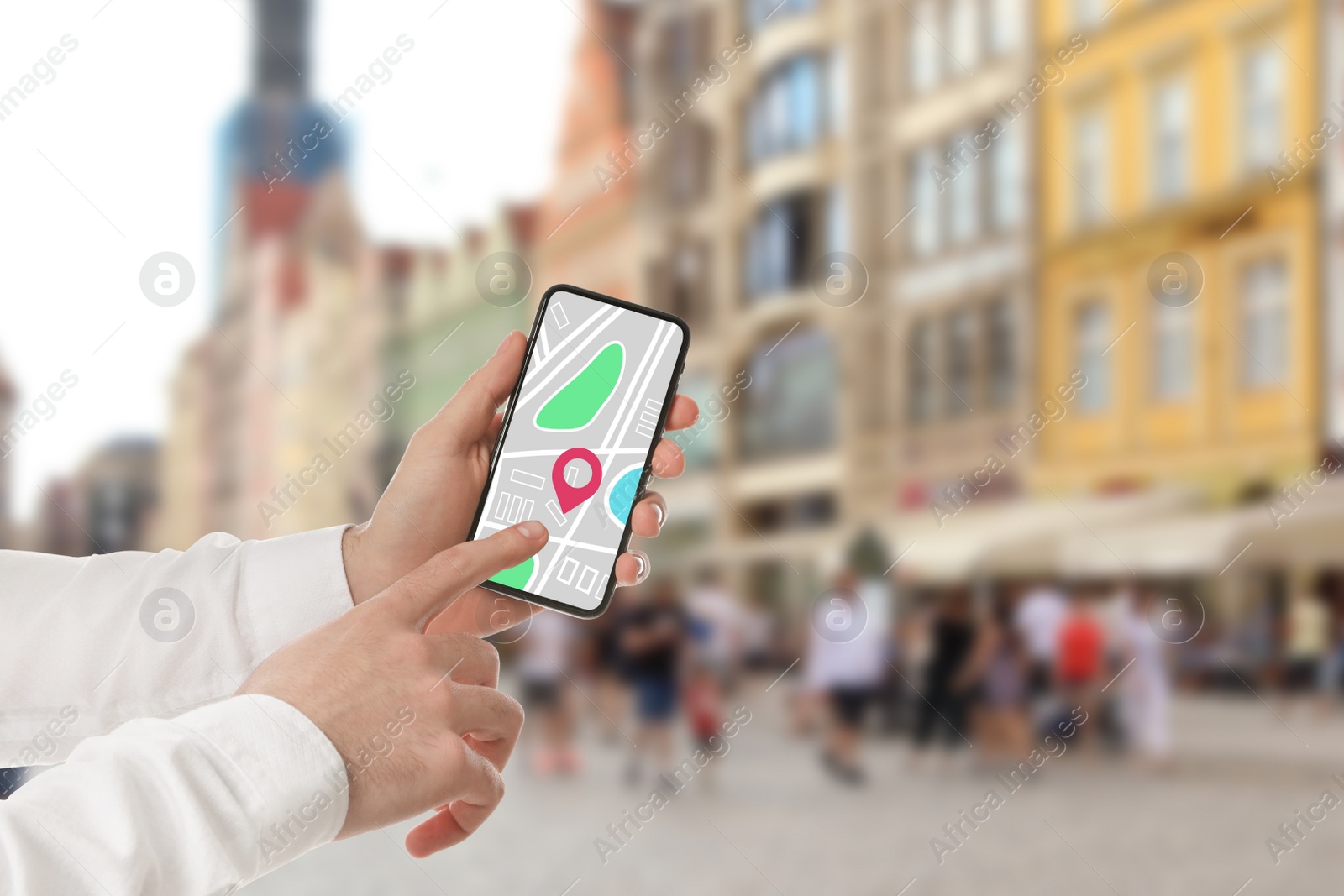 Image of Man searching location with smartphone in city, closeup. Space for text 