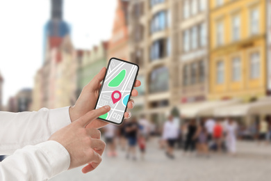 Image of Man searching location with smartphone in city, closeup. Space for text 