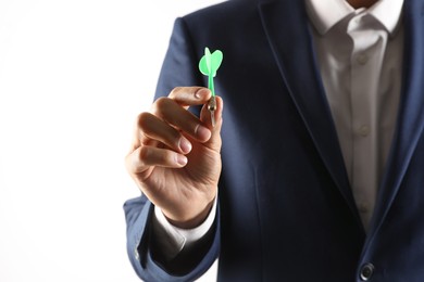 Man holding green dart on light background, closeup