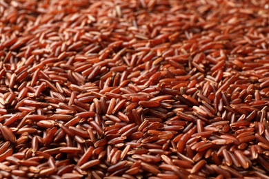 Raw brown rice as background, closeup view