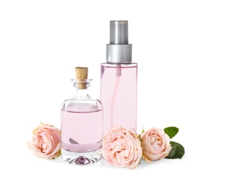 Photo of Bottles of essential oil and roses on white background