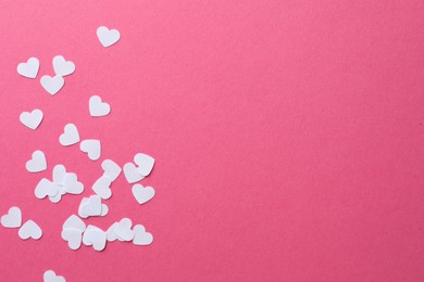 Photo of White paper hearts on pink background, flat lay. Space for text