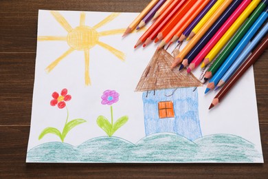 Cute child`s drawing and colorful pencils on wooden table, flat lay