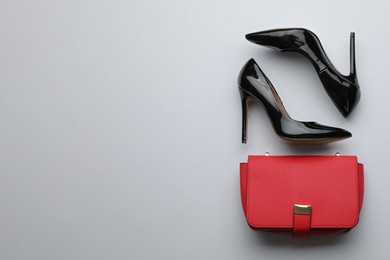 Photo of Stylish woman's bag and shoes on light background, flat lay