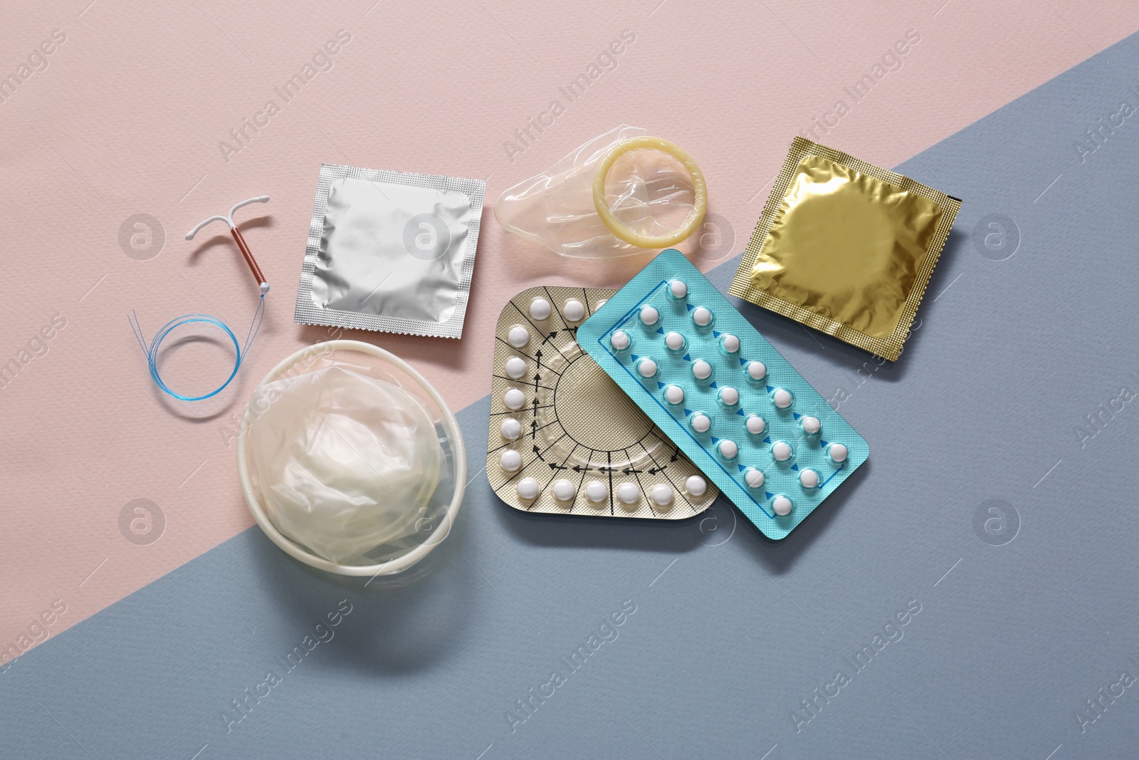 Photo of Contraceptive pills, condoms and intrauterine device on beige background, flat lay. Different birth control methods