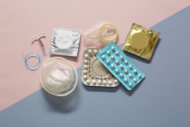 Contraceptive pills, condoms and intrauterine device on beige background, flat lay. Different birth control methods