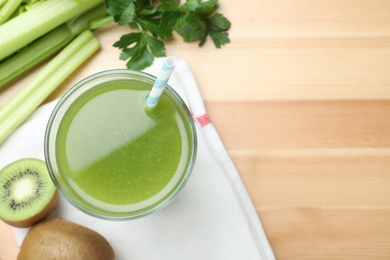 Photo of Glass of fresh celery juice on wooden table, flat lay. Space for text