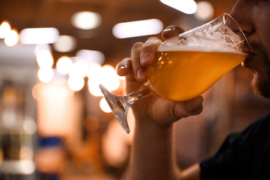 Photo of Man drinking cold tasty beer at festival, closeup