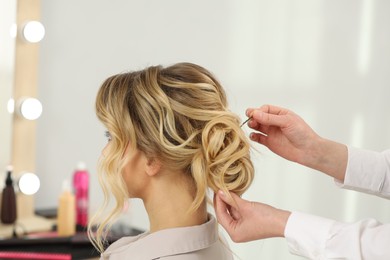 Hair styling. Professional hairdresser working with client indoors, closeup