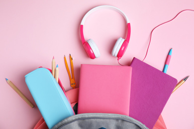 Flat lay composition with books and headphones on pink background