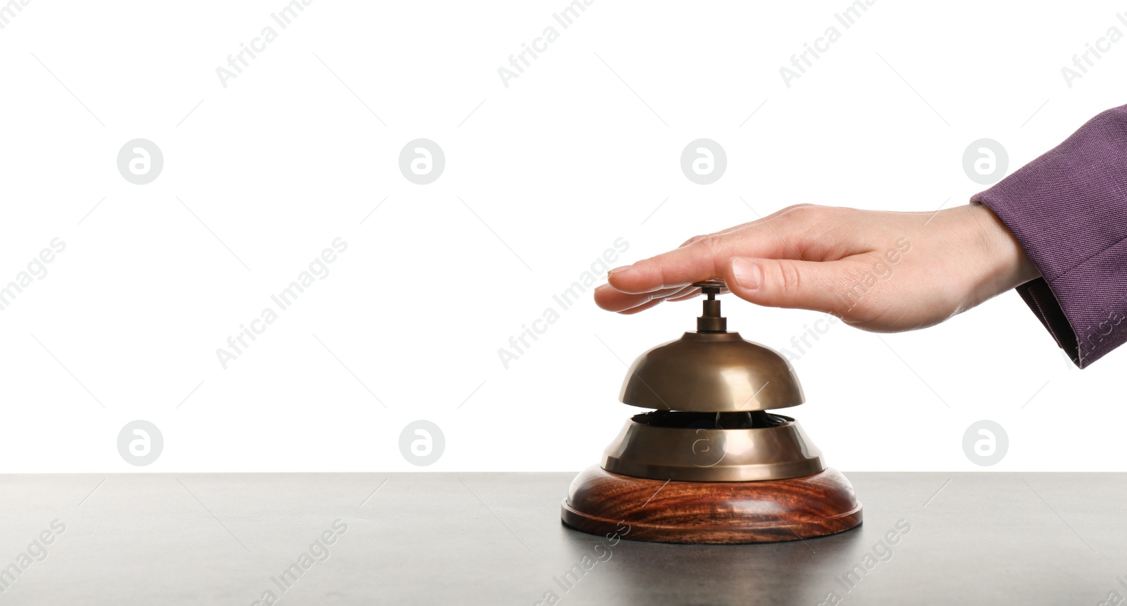 Photo of Woman ringing hotel service bell at grey stone table