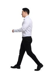 Businessman in formal clothes walking on white background