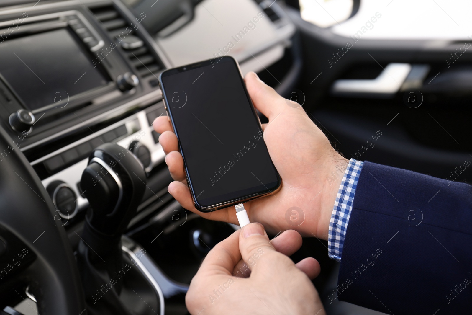 Photo of Man charging phone with USB cable in car