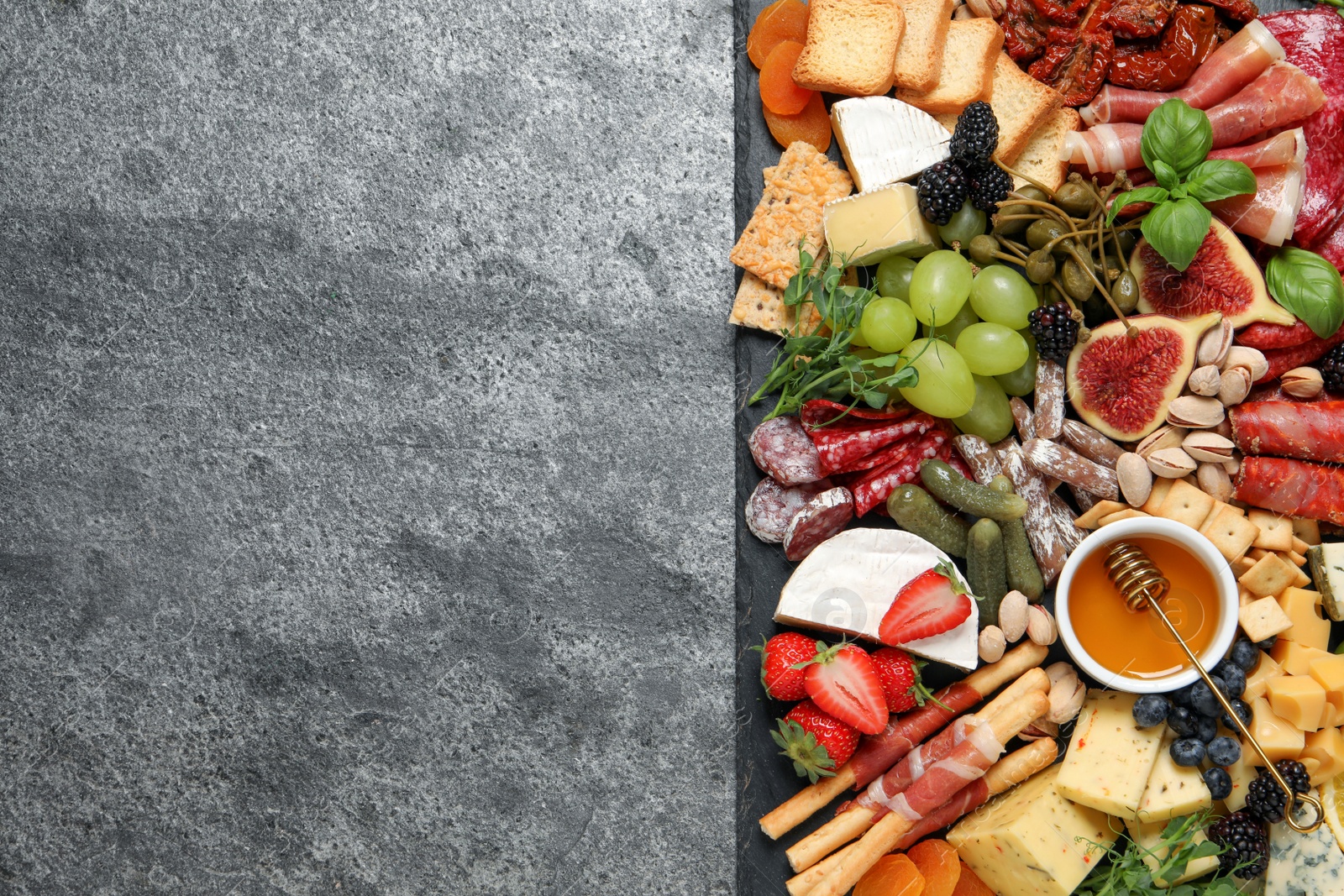 Photo of Set of different delicious appetizers served on grey table, top view. Space for text