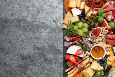Photo of Set of different delicious appetizers served on grey table, top view. Space for text