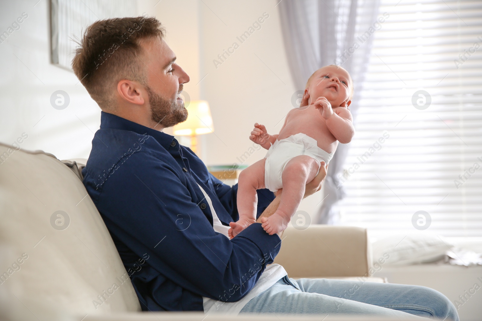 Photo of Father with his newborn son at home